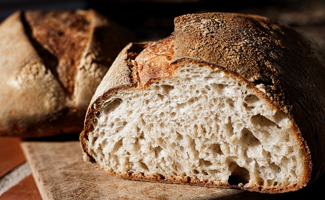 A cut sourdough loaf showing an open, glossy crumb